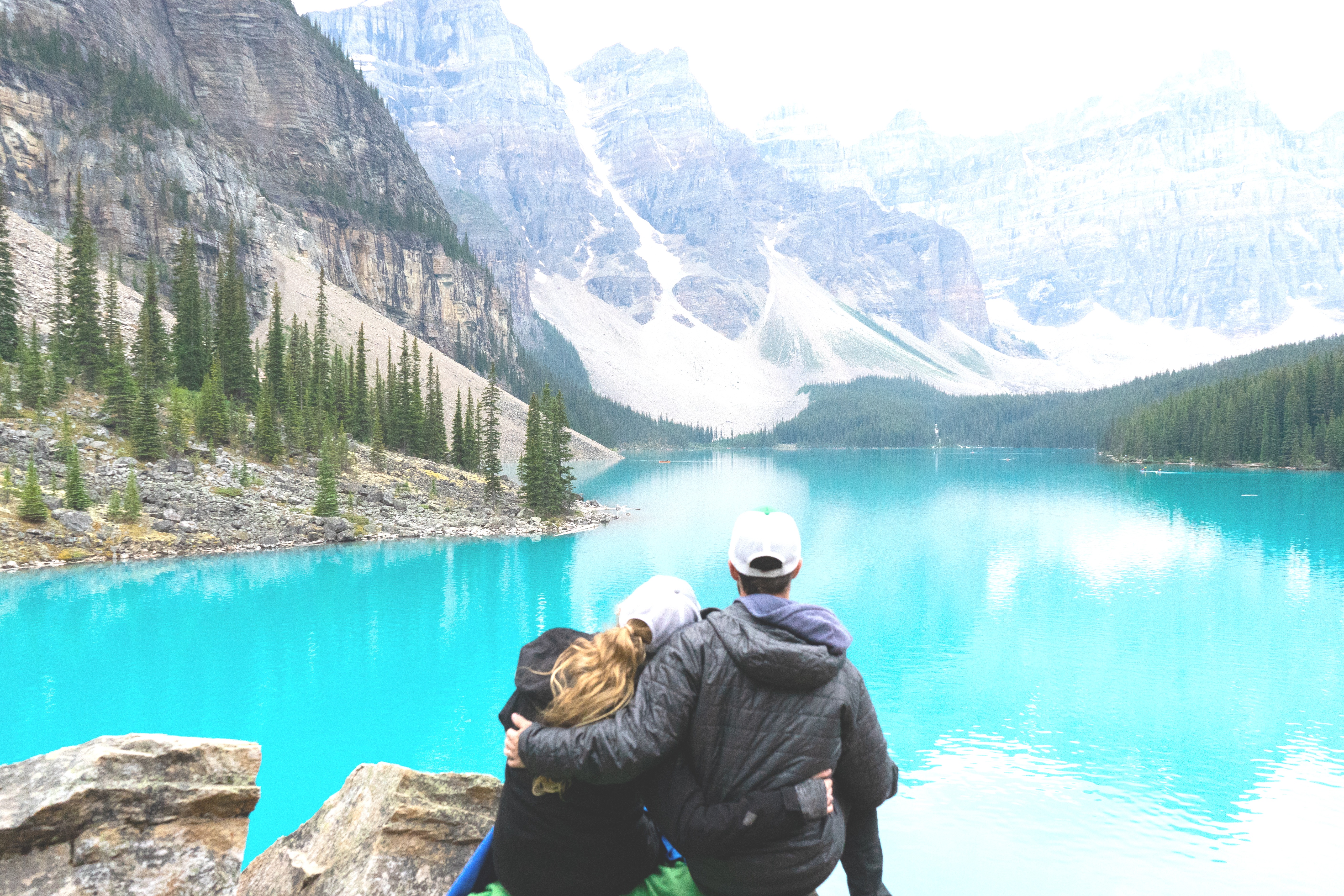 cuddling couple on a mountain overseeing a lake